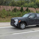 The Toyota Tacoma truck is disguised by a black wrap all over